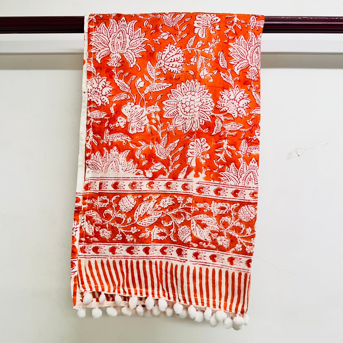 Orange scarf with white floral and striped patterns