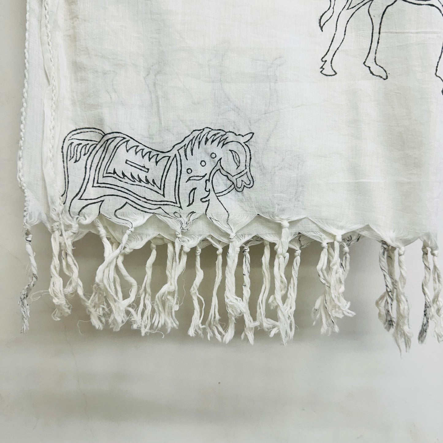 White Cotton scarf with black horse patterns and fringes on a whit