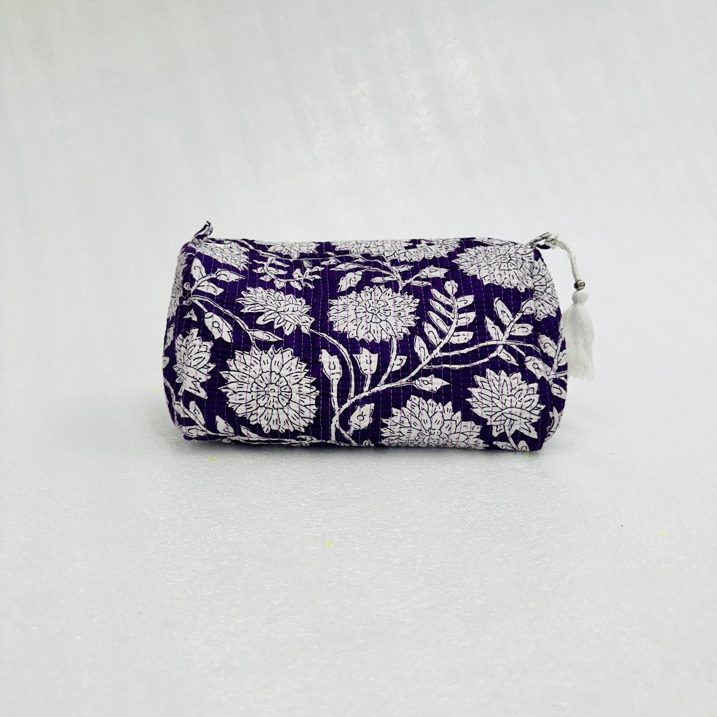 White floral-patterned on a violet  pouch on a white background