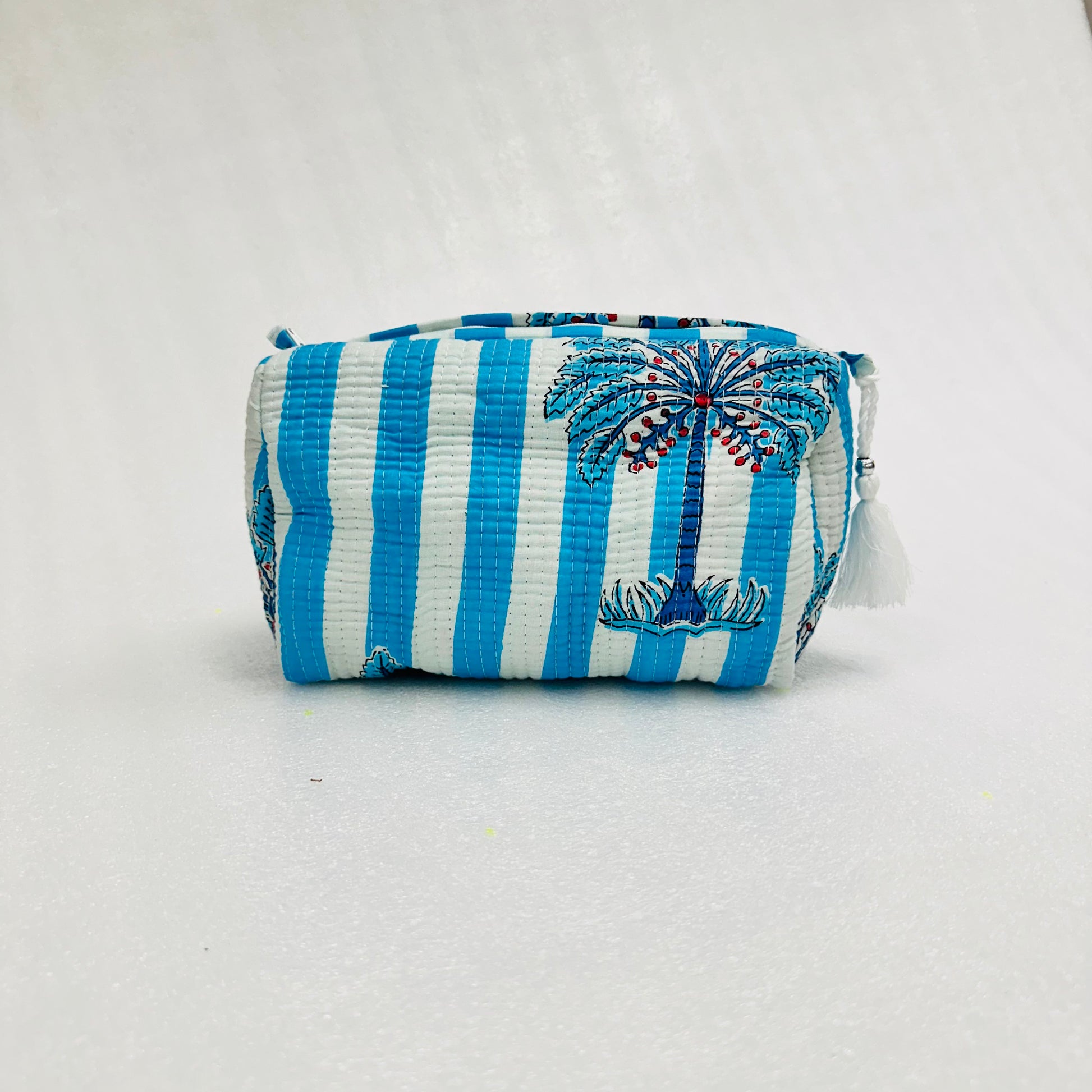 Blue and white striped pouch with palm tree design on a light gray background