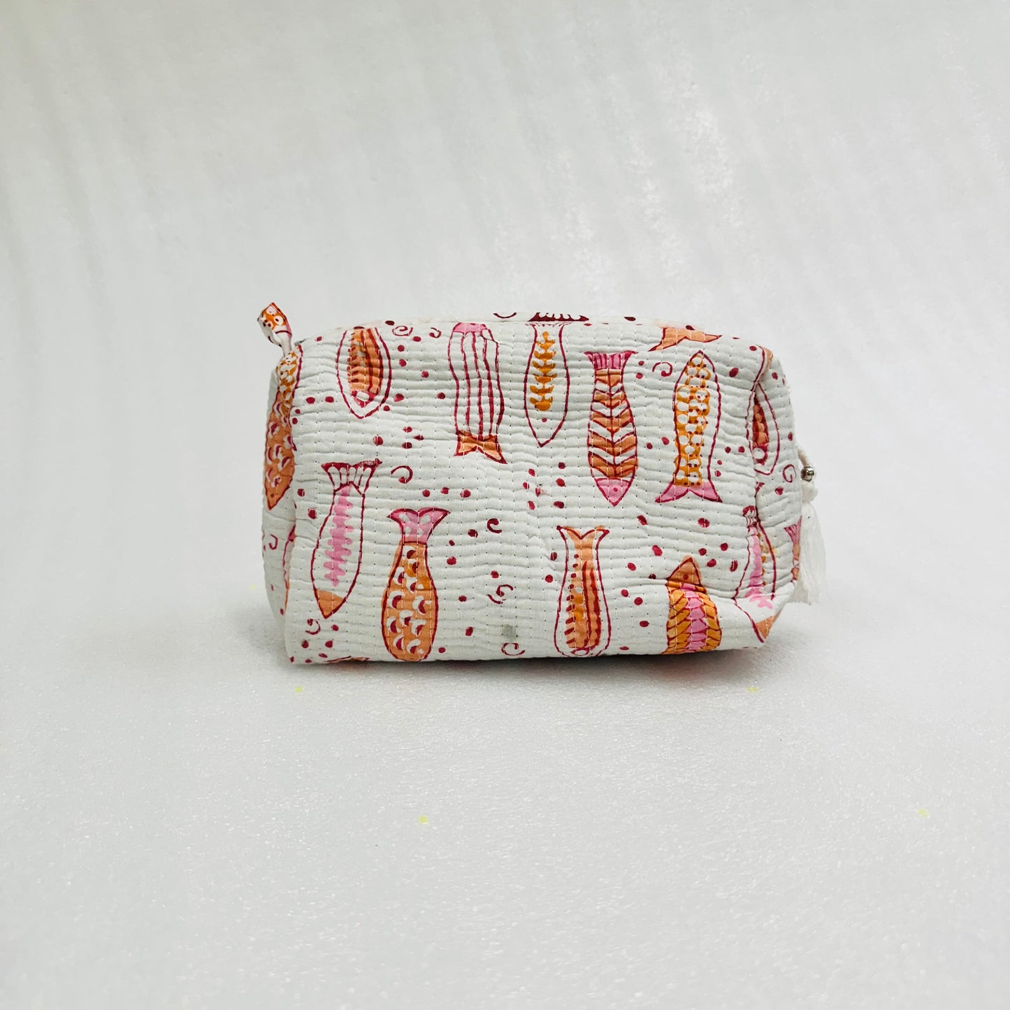 Fabric pouch with fish pattern on a light gray background
