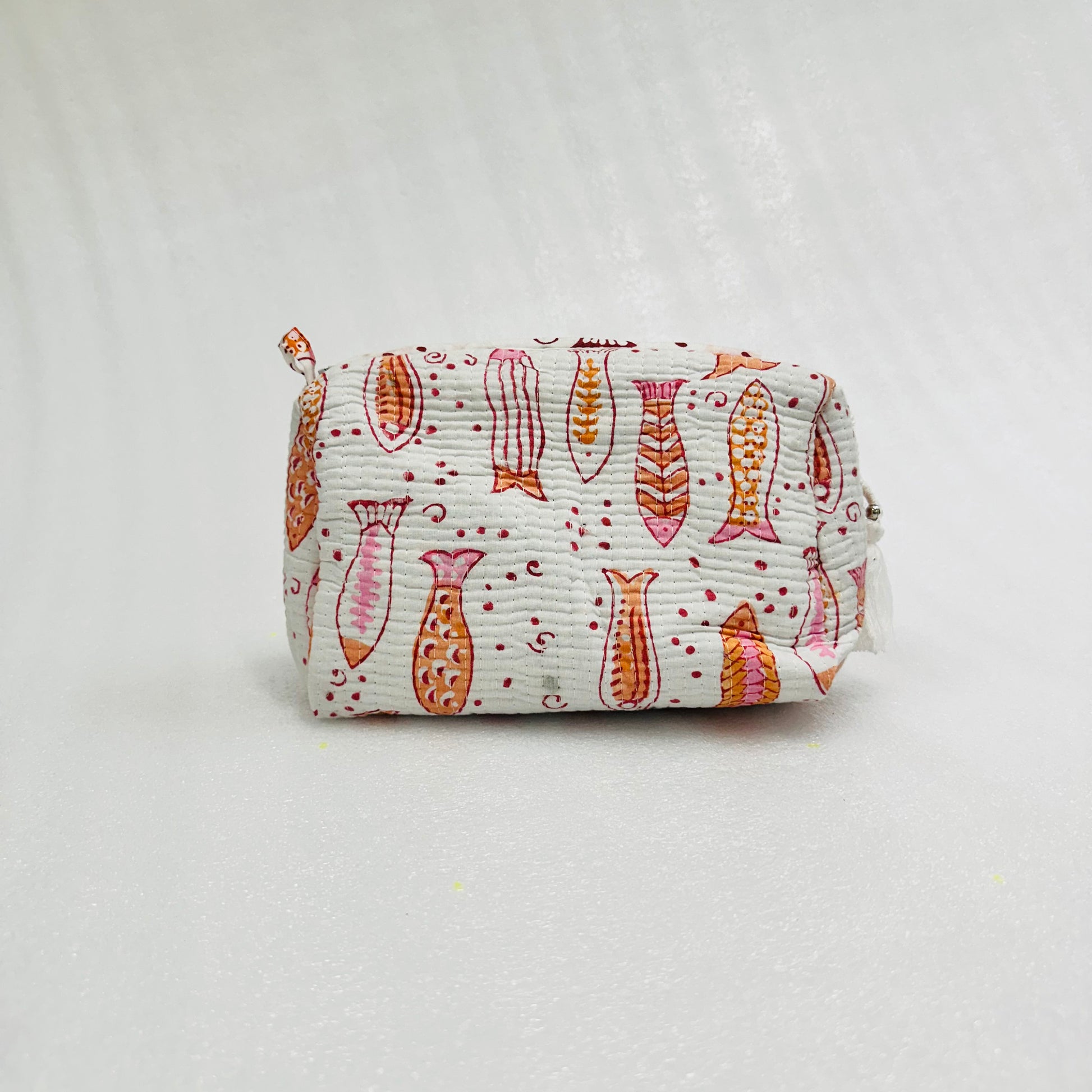 Fabric pouch with fish pattern on a light gray background